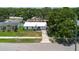 Aerial view of property showcasing a white roof, landscaping, and driveway at 706 E Gate Dr, Safety Harbor, FL 34695