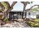Charming backyard featuring mature trees, a screened in porch, and decorative gravel at 706 E Gate Dr, Safety Harbor, FL 34695