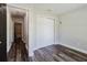 Small bedroom with wood-look flooring, closet, and view of the hallway and bathroom at 706 E Gate Dr, Safety Harbor, FL 34695