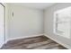 Compact bedroom with wood-look flooring, neutral walls, closet, and bright window at 706 E Gate Dr, Safety Harbor, FL 34695