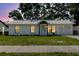 Charming single-story home featuring a white exterior, well-maintained lawn, and mature trees in background at 706 E Gate Dr, Safety Harbor, FL 34695