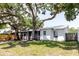 Charming home exterior featuring mature trees, a screened-in porch, and a well-maintained lawn at 706 E Gate Dr, Safety Harbor, FL 34695