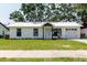 Charming one-story home featuring a well-maintained lawn and a light colored exterior at 706 E Gate Dr, Safety Harbor, FL 34695