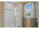 Modern bathroom featuring a walk-in shower with glass doors and a tiled surround complemented by a window with stylish curtains at 8636 Prairie Creek Dr, New Port Richey, FL 34655