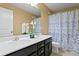 Bathroom with a double sink vanity, a large mirror, and a bathtub with a decorative shower curtain at 8636 Prairie Creek Dr, New Port Richey, FL 34655