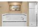 Clean bathroom with a white tub, tile surround, and shower, with a mirror at 8636 Prairie Creek Dr, New Port Richey, FL 34655