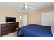 Inviting bedroom with a blue comforter, a dresser with a TV, and neutral walls and flooring at 8636 Prairie Creek Dr, New Port Richey, FL 34655