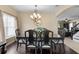 Formal dining room boasts dark wood floors, chandelier, and views to living room with stairs at 8636 Prairie Creek Dr, New Port Richey, FL 34655
