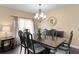 Dining room with a dark wood table set, decorative chandelier, and a large window at 8636 Prairie Creek Dr, New Port Richey, FL 34655