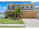 Inviting two-story home featuring a manicured lawn, tropical landscaping, and a two-car garage at 8636 Prairie Creek Dr, New Port Richey, FL 34655