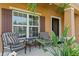 Inviting front porch with seating, lush landscaping, and a view of the home's exterior features at 8636 Prairie Creek Dr, New Port Richey, FL 34655