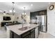 Open kitchen featuring an island, granite countertops, and black cabinets and stainless steel appliances at 8636 Prairie Creek Dr, New Port Richey, FL 34655