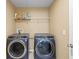 Modern laundry room features side-by-side washer and dryer units, plus wire rack shelving at 8636 Prairie Creek Dr, New Port Richey, FL 34655