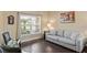 Cozy living room with hardwood floors, neutral walls, and large windows providing ample natural light at 8636 Prairie Creek Dr, New Port Richey, FL 34655