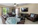 Inviting living room with comfortable brown leather seating, a ceiling fan, and plenty of natural light at 8636 Prairie Creek Dr, New Port Richey, FL 34655