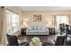 Cozy living room with hardwood floors, neutral walls, and large windows providing ample natural light at 8636 Prairie Creek Dr, New Port Richey, FL 34655