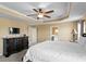 Spacious main bedroom with a tray ceiling, fan, and a dark wood dresser with a marble top at 8636 Prairie Creek Dr, New Port Richey, FL 34655