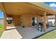 Covered outdoor patio featuring BBQ, table and chairs, and entry to main house at 8636 Prairie Creek Dr, New Port Richey, FL 34655