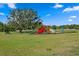 Community playground with slides, climbing equipment, and a large shade tree at 8636 Prairie Creek Dr, New Port Richey, FL 34655