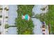 Aerial view of a condo community featuring mature trees and a pristine blue community pool at 9205 Jakes Path, Largo, FL 33771