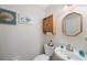 Well-maintained half bath features a decorative mirror and seashell-themed decor at 9205 Jakes Path, Largo, FL 33771