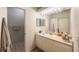Bathroom featuring a large mirror with lighting, a vanity with storage, and a doorway to the toilet at 9205 Jakes Path, Largo, FL 33771