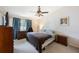Cozy bedroom features neutral walls, ceiling fan, plush carpet, and lots of natural light at 9205 Jakes Path, Largo, FL 33771