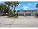 Charming two-story condo featuring a spacious driveway, gray garage door, and mature palm trees at 9205 Jakes Path, Largo, FL 33771