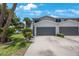 Charming two-story condo featuring a spacious driveway, gray garage door, and beautifully landscaped yard at 9205 Jakes Path, Largo, FL 33771