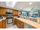 Well-equipped kitchen features stainless steel appliances and a view of the living area at 9205 Jakes Path, Largo, FL 33771