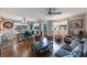 Open-concept living and dining area with wood floors, ceiling fans, and sliding glass door to the outside at 9205 Jakes Path, Largo, FL 33771