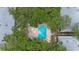 Stunning aerial view of a sparkling pool and jacuzzi surrounded by lush trees and landscaping at 9205 Jakes Path, Largo, FL 33771