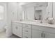 Bright bathroom with dual sinks, white cabinets and a large mirror, creating a fresh and modern space at 9815 Carabiner Way, Land O Lakes, FL 34637