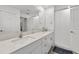 Bright bathroom featuring double sinks with quartz countertop and white cabinets at 9815 Carabiner Way, Land O Lakes, FL 34637