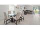 Dining room with a modern glass-top table and seating for six, conveniently located adjacent to the living area at 9815 Carabiner Way, Land O Lakes, FL 34637