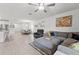 Spacious living room with tile flooring, a ceiling fan, and ample natural light creating an inviting atmosphere at 9815 Carabiner Way, Land O Lakes, FL 34637