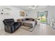 Comfortable living room features tile floors, a ceiling fan, and sliding glass doors leading to the backyard at 9815 Carabiner Way, Land O Lakes, FL 34637