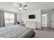Relaxing main bedroom featuring a ceiling fan, plush carpet, and a view of the en-suite bathroom at 9815 Carabiner Way, Land O Lakes, FL 34637