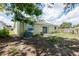 View of the green home's backyard featuring a concrete patio and AC unit at 1040 Bridlewood Way, Brandon, FL 33511