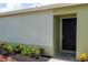 Close-up of the home's entrance, showcasing the black front door and manicured landscaping at 1040 Bridlewood Way, Brandon, FL 33511