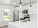 Updated kitchen with stainless steel appliances, white cabinetry, solid surface countertops, and modern fixtures at 1040 Bridlewood Way, Brandon, FL 33511