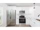Contemporary kitchen with stainless steel appliances, including fridge and oven, and sleek white cabinetry at 1040 Bridlewood Way, Brandon, FL 33511