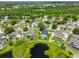 An aerial of a neighborhood highlighting the backyard with a screened pool and lake in the background at 10430 Crestfield Dr, Riverview, FL 33569
