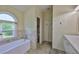 A well-lit bathroom with a soaking tub and window at 10430 Crestfield Dr, Riverview, FL 33569