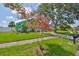 Landscaped front yard with a flowering tree complements the home's colorful exterior at 10430 Crestfield Dr, Riverview, FL 33569