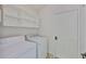 Clean laundry room with washer, dryer, and storage shelves above at 10430 Crestfield Dr, Riverview, FL 33569