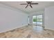 Bright living room features tile floors, ceiling fan, and sliding glass doors to the pool at 10430 Crestfield Dr, Riverview, FL 33569