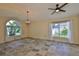 Bright living room with tiled floors, large windows, chandelier, and ceiling fan at 10430 Crestfield Dr, Riverview, FL 33569