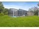 This grassy backyard features a screened-in pool, ideal for relaxation and enjoyment at 10462 Lucaya Dr, Tampa, FL 33647