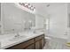 Bathroom featuring double sinks with white countertops, vanity and large mirror over the sinks, tub, and shower at 10462 Lucaya Dr, Tampa, FL 33647